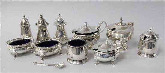 Ten assorted silver condiments including mustards, salts and peppers.